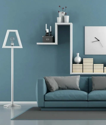 Stylish blue sofa with a decorative clock on a shelf, showcasing modern interior design elements.