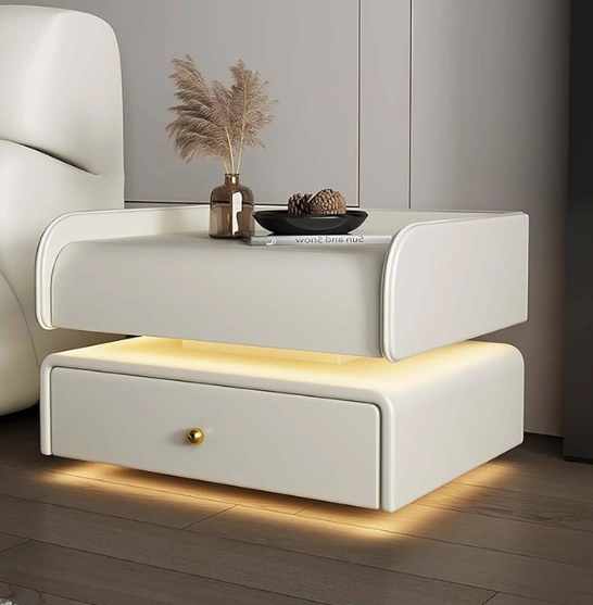 Minimalist nightstand with soft curves, built-in drawer, underlighting, adorned with a vase & decor items.