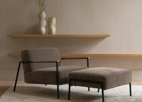 A stylish accent chair and ottoman in a modern room with a sleek shelf, showcasing style and comfort
