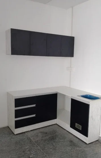 A stylish corner kitchen counter featuring a wall cabinet & a vibrant blue basin for a modern touch.