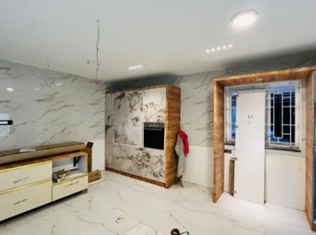 A Modern room with stunning marble walls, wooden accents, a built-in oven, and a door to the right.