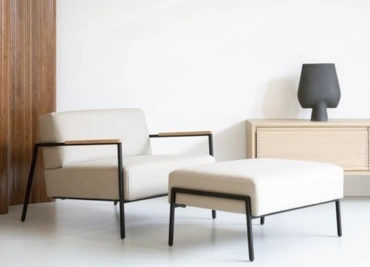 A stylish modern chair and ottoman in a room, adding a pop of color and comfort to the space.