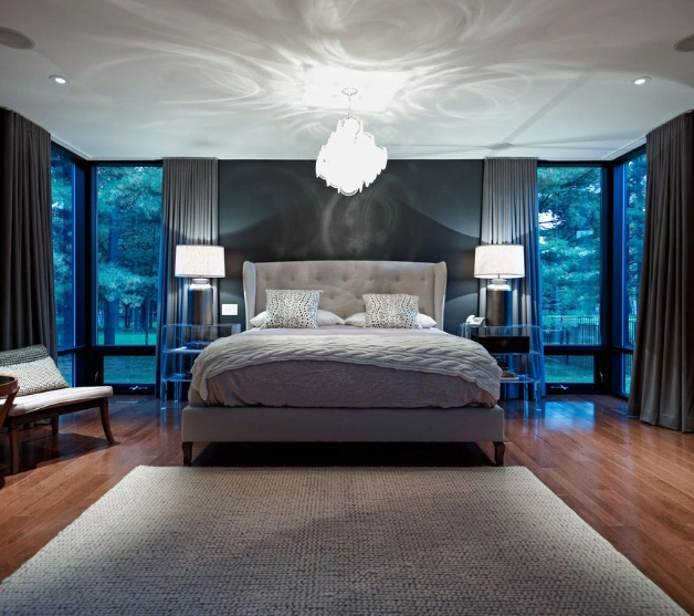 Luxurious bedroom with a spacious bed and chandelier, showcasing top interior designers' expertise.