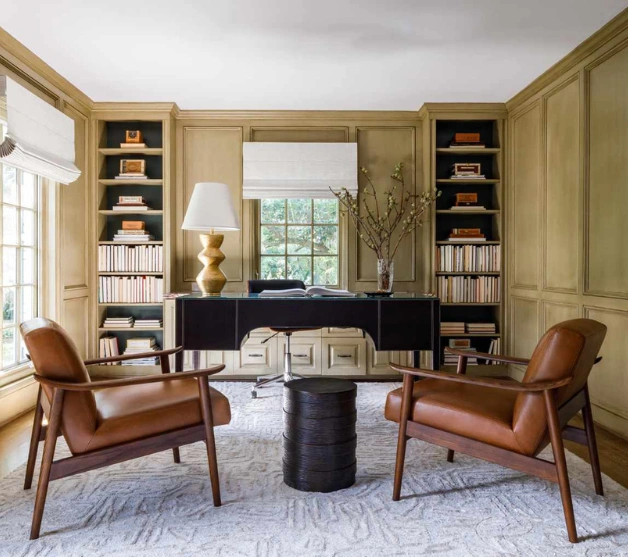 Top interior designers created a stylish home with leather chairs and a modern desk for study.