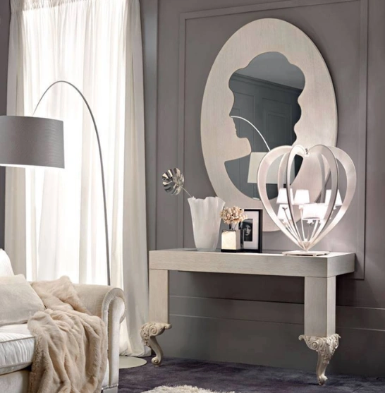 White couch elegantly positioned in a foyer, with a stylish mirror reflecting the room’s ambiance.