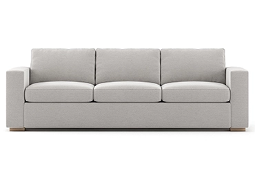 A gray couch elegantly positioned in a well-lit living room, showcasing its modern design & comfort.