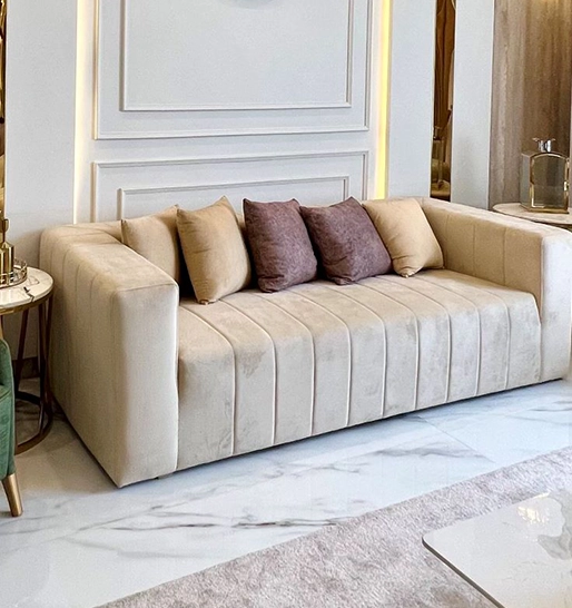 A cozy living room featuring a couch, a stylish coffee table, and a warm lamp illuminating the space.